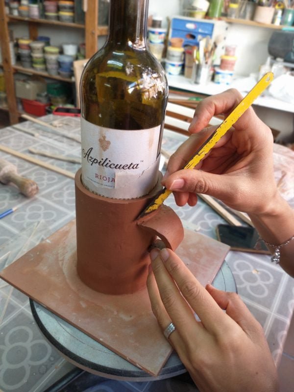 Artista creando funda de cerámica para botella